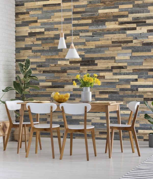 White chairs at wooden table with yellow flowers in dining room interior with plants. Real photo